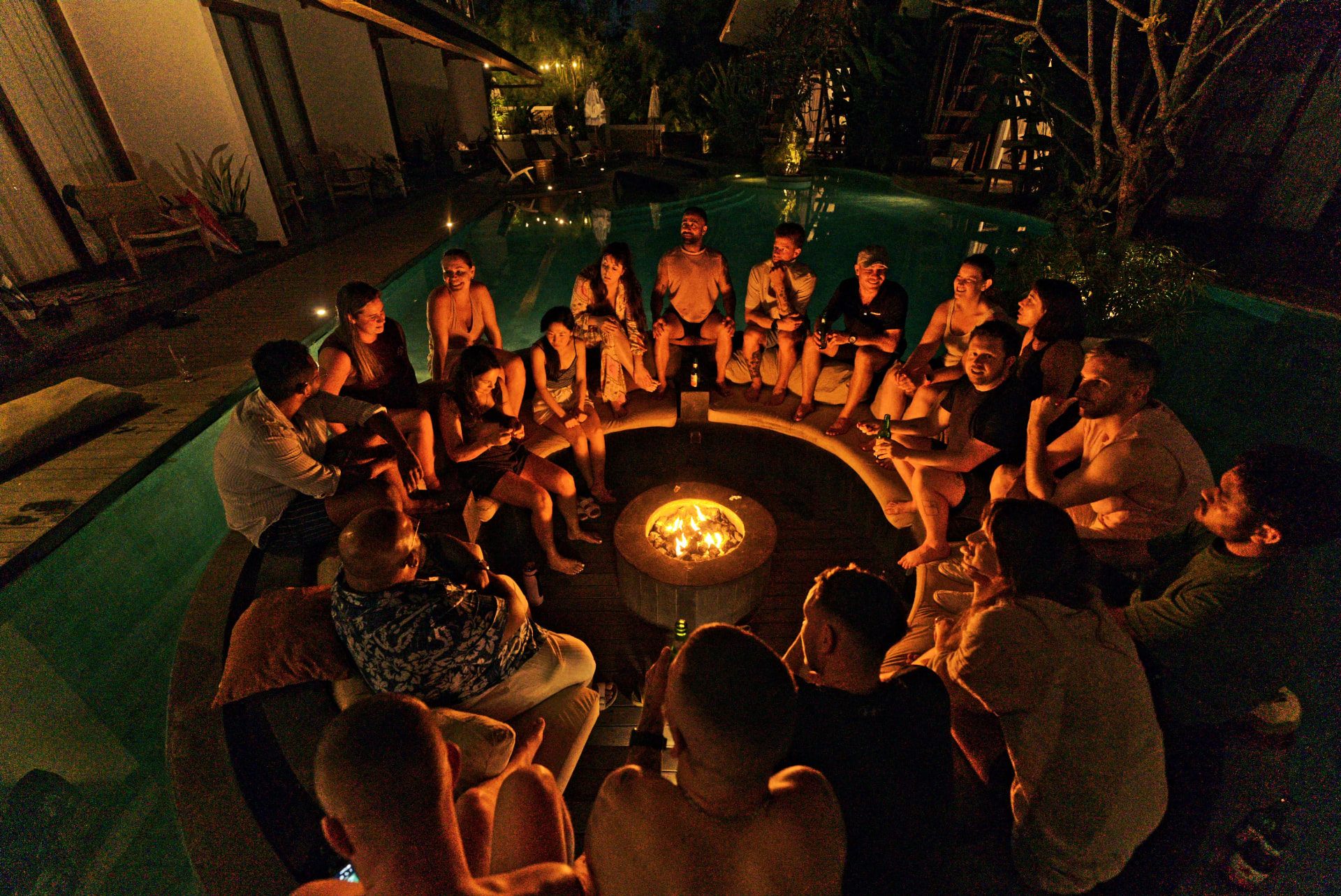 Founders gathered around the pool fire pit at night