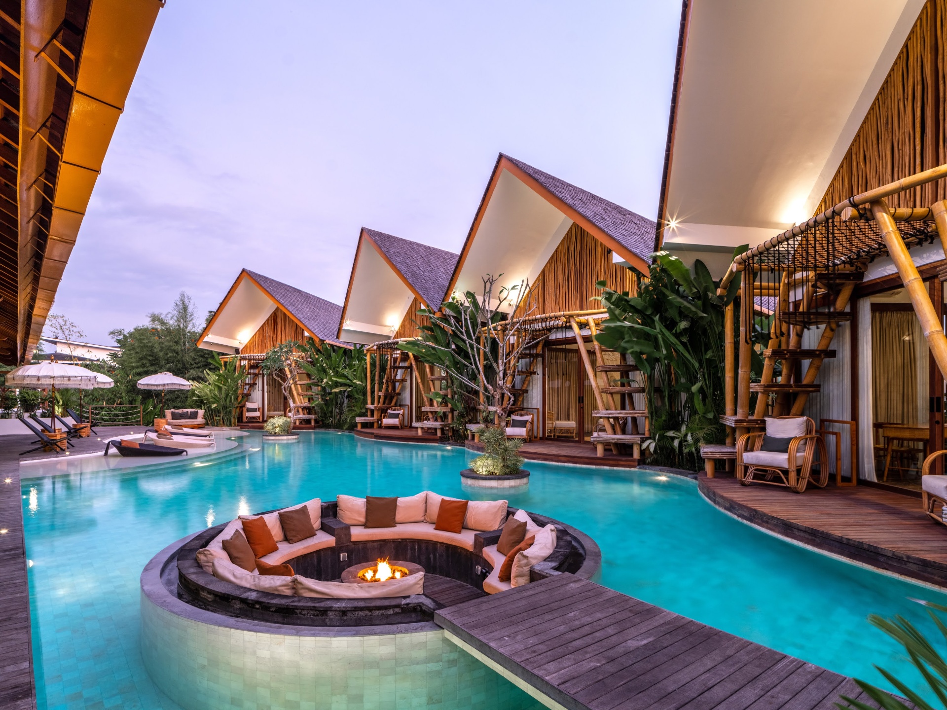 Villa pool and bungalows at sunset