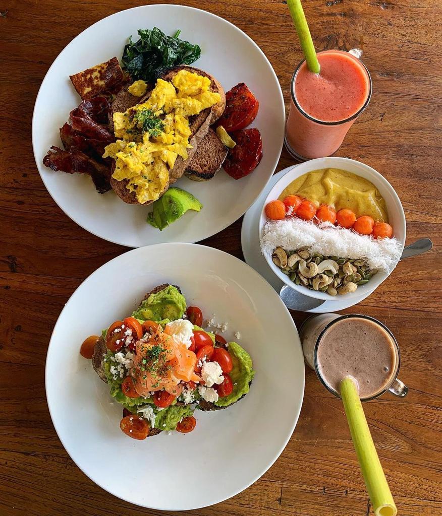 Fresh breakfast spread with avocado toast, smoothie bowls, and juices